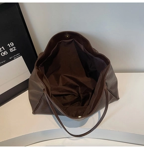 Detail view of large dark brown tote bag with magnetic closure and spacious interior