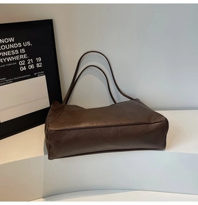 Detail view of large dark brown retro faux leather tote bag with long shoulder straps