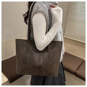 Model wearing dark brown vintage leather tote bag with large capacity for commuting