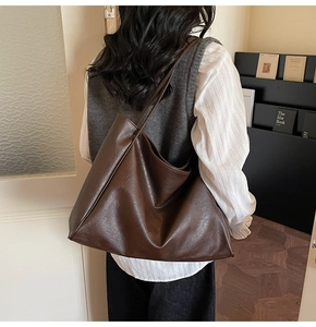 Detail of soft dark brown leather tote bag showing large capacity and fine texture