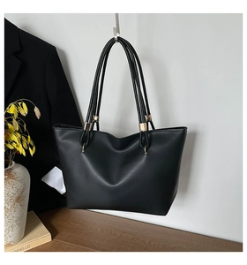 Détails du sac fourre-tout en cuir noir avec d'élégants accents d'anneaux métalliques dorés