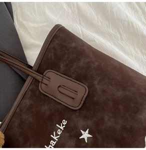 Detail of retro dark brown suede tote bag with white haKeke star embroidery