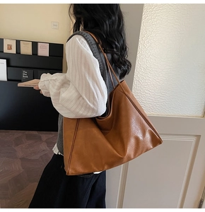 Detail of caramel brown large capacity tote bag with vintage texture and shoulder straps