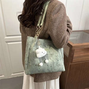 Light green star and moon tote bag with chain strap and cloud plush charm in casual use