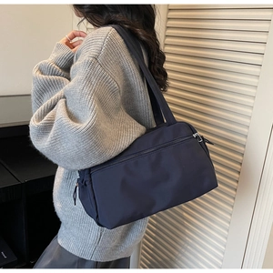 Detail view of a large navy nylon tote bag showing double straps and side structure