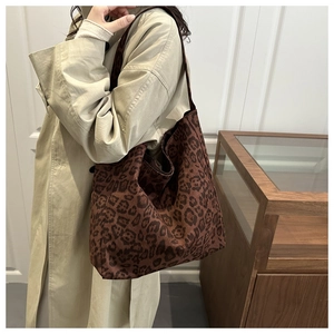 Detailed close-up of a large leopard print tote bag with soft texture on a shoulder strap
