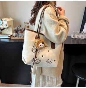 Chic beige tote bag featuring cat illustration worn by model in a vintage cafe