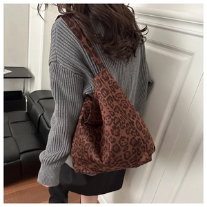 Detailed back view of a large leopard print tote bag styled with a grey knitted sweater
