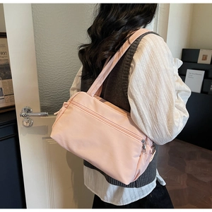Detail view of a pink canvas tote bag with a front zipper pocket and double straps