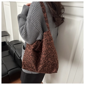 Shoulder view of a large leopard print canvas tote bag for women in stylish winter fashion