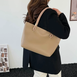 Grand sac cabas kaki en cuir ciré porté par un mannequin dans un cadre minimaliste