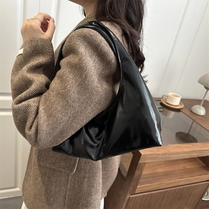 Glossy black patent leather tote bag styled with a blazer for a modern aesthetic look
