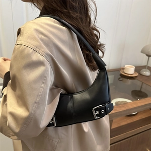Sac hobo noir minimaliste avec boucle argentée porté par une femme mannequin