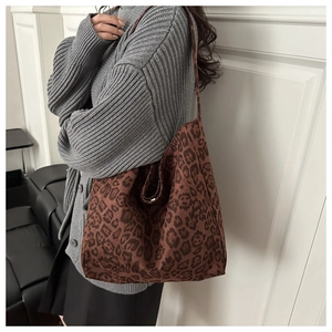 Chic leopard print tote bag styled with a gray cardigan and minimalist studio backdrop
