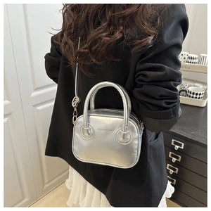 Detail showing the silver metallic quilted crossbody bag with a slim shoulder strap