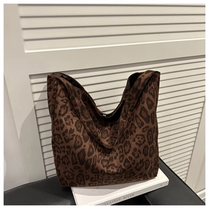 Detail view of large leopard print hobo bag with fuzzy texture on a book display