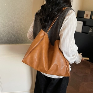 Chic caramel brown faux leather large tote bag for women in a stylish lifestyle setting