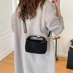 Minimalist black matte crossbody pillow bag with adjustable strap and top handle design