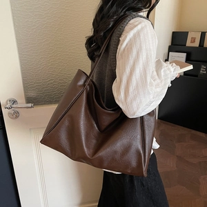 Minimalist large capacity dark brown tote bag with vintage texture shown on shoulder