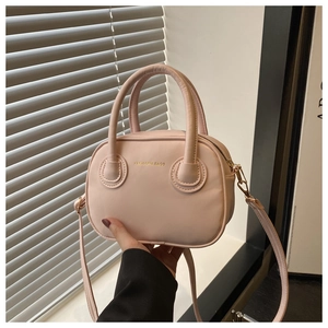 Détail du petit sac à main rose avec fermeture éclair dorée et bandoulière