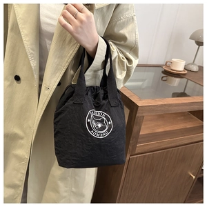 Détail du sac cordon en nylon étanche avec logo chat blanc et poignée tissée noire