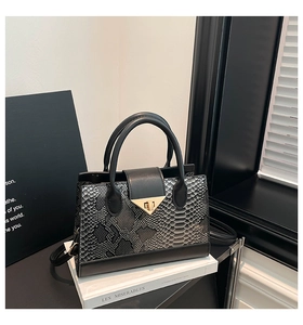 Macro detail of snakeskin pattern leather handbag with golden triangle twist lock closure