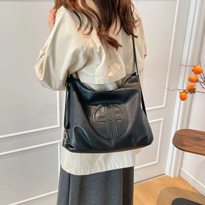 Vintage black faux leather tote bag with embossed logo and adjustable wide shoulder strap