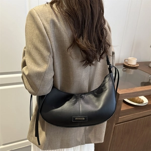 Minimalist black leather crescent hobo bag with sleek metal detail and slim shoulder strap