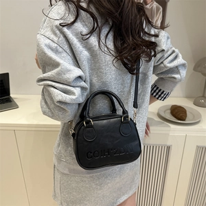 Minimalist black faux leather Boston bag with embossed logo and dual top handles