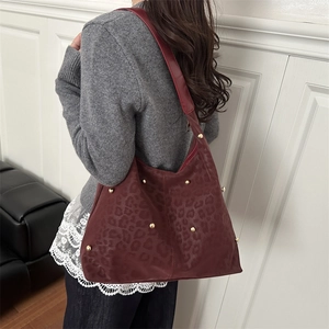 Grande borsa tote bordeaux con trama leopardata, borchie dorate e tracolla larga