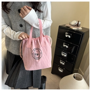 Vue détaillée d'un sac seau rose à cordon avec un logo de chat mignon pour le quotidien