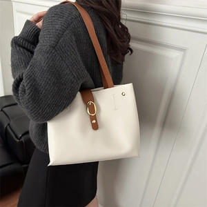 Minimalist white tote bag with brown straps and gold buckle for daily commuting