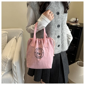 Détail du sac seau imperméable rose avec cordon de serrage et logo noir tendance