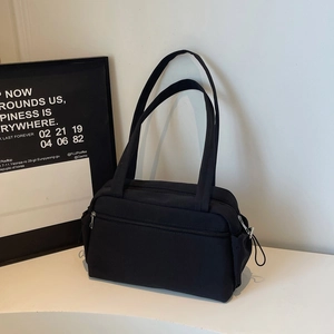 Sac fourre-tout minimaliste en toile noire avec plusieurs poches et bretelles d'épaule