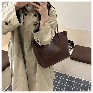 Minimalist deep brown leather tote bag shown on shoulder for daily styling and size reference