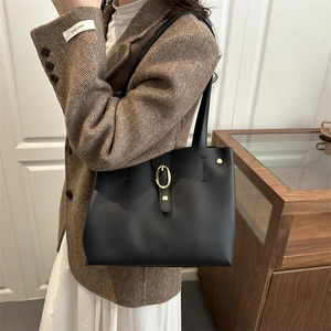 Minimalist black leather tote bag for women with gold oval buckle and stylish shoulder strap