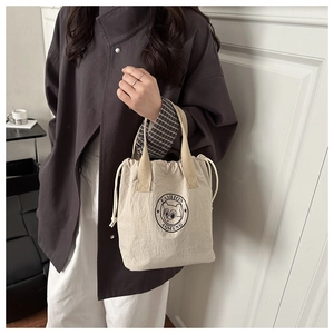 Détail du sac à provisions en toile beige avec cordon de serrage et imprimé cartoon
