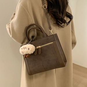 Retro brown suede crossbody bag with metal zipper and plush charm for daily commute
