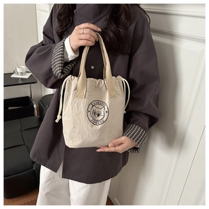 Détail du sac seau imperméable avec imprimé ours et texture de tissu souple et douce