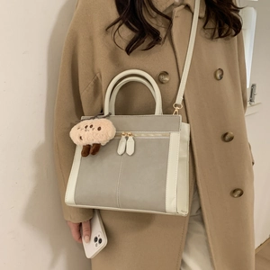 Retro minimalist square crossbody bag in grey and cream leather with a plush charm