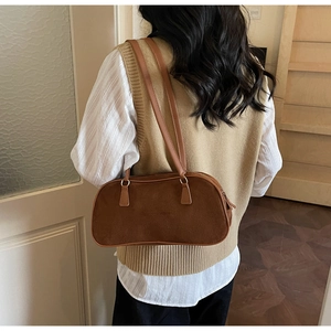 Brown suede underarm bag shown on model with vintage minimalist leather shoulder straps