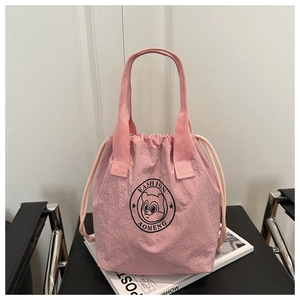 Détail d'un sac seau en nylon rose avec cordon et logo de dessin animé d'écureuil