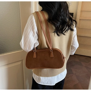 Detail view of the brown frosted suede texture and long slim straps on retro shoulder bag