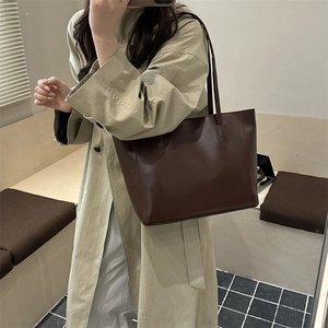 Minimalist deep brown leather tote bag for women shown in a stylish mirror selfie