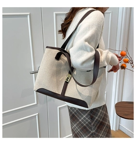 Detail of canvas and brown leather tote bag with vintage gold twist lock and dual handles