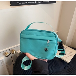 Détail du sac bandoulière en nylon bleu Tiffany avec zips argentés et sangle réglable