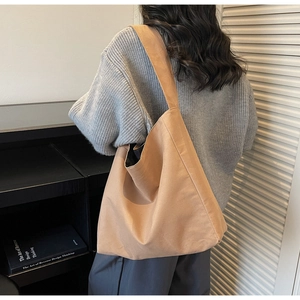 Detailed view of the wide shoulder strap and soft canvas texture on this khaki tote bag