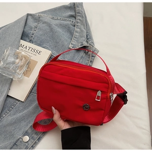 Détails du sac bandoulière en nylon rouge avec poches zippées et sangle réglable