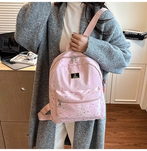 Detailed view of pink star-patterned backpack with silver hardware and adjustable straps