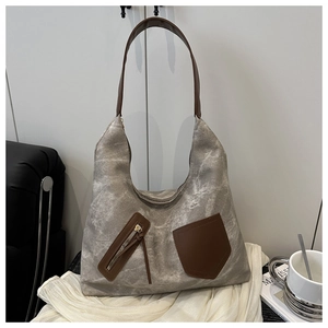 Close-up of marble texture tote bag with brown leather straps and front zipper detail